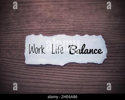 Motivierende und inspirierende Zitate - Work-Life-Balance. Kleines Zerreisspapier und Holzfußboden im Hintergrund. Motivationskonzept. Stockfoto