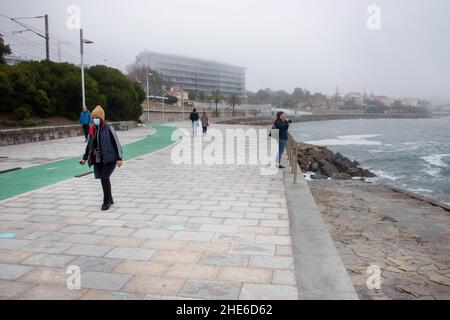 Cascais, Portugal. 03rd Januar 2022. Eine Frau, die eine Schutzmaske trägt, wird gesehen, wie sie entlang einer Promenade in der Nähe der Küste von Cascais spazierengeht. Portugal verzeichnete seit Beginn der Pandemie 1.577.784 Fälle und 19.071 Todesfälle im Zusammenhang mit Covid-19, so das Bulletin der Generaldirektion Gesundheit (DSG). (Foto von Jorge Castellanos/SOPA Images/Sipa USA) Quelle: SIPA USA/Alamy Live News Stockfoto