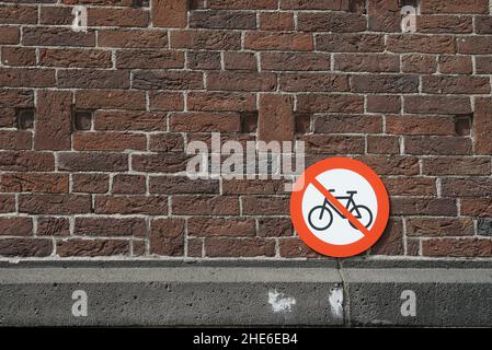 Fahrradparken verboten, ein rundes Metallschild an einer Backsteinmauer in der Altstadt von Rotterdam, Niederlande, Europa. Stockfoto