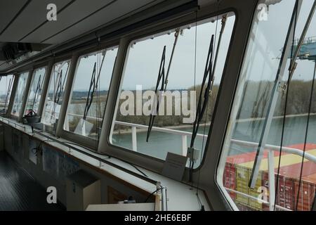 Blick von den Frontscheiben mit Scheibenwischern auf die Navigationsbrücke des Containerschiffes. Stockfoto