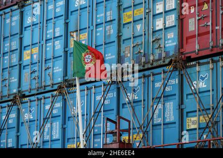 Flagge Portugals auf weißem Mast, der sich im hinteren oder hinteren Teil des Containerschiffes befindet. Stockfoto