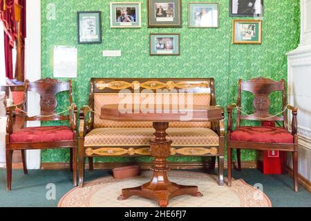 Irkutsk, Russland 30. Juli 2021 - Haus des Dezembristen Trubetskoi Sergei Petrowitsch. Möbel auf dem Hintergrund der Wand mit Porträts Stockfoto