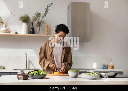 Happy Pretty Black Mädchen genießen Kochen Hobby, Hacken frisches Gemüse Stockfoto