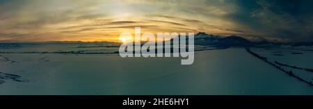 Winter Berglandschaft bei Sonnenuntergang. Sonne und Gipfel in der Hohen Tatra, Slowakei Stockfoto