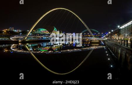 Die Brücken über den Fluss Tyne spiegeln sich nachts im Wasser, in Newcastle England Stockfoto