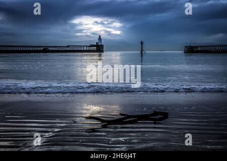 Ein herrlicher Morgen am Blyth Beach in Northumberland bei Sonnenaufgang, mit einem ausgewaschenen Zweig auf dem Sand Stockfoto