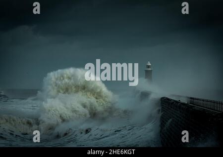 Riesige Wellen schlagen den Leuchtturm und den Nordpier, der die Mündung des Tyne in Tynemouth, England, bewacht Stockfoto