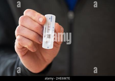 Positiver Covid-19-Lateral-Flow-Test, durchgeführt von Mann mittleren Alters - Schottland, Großbritannien Stockfoto