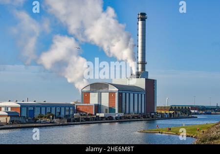 Brighton UK 9th January 2022 - Spaziergänger kommen an einem schönen sonnigen, aber kalten Tag an der Südküste am Gaskraftwerk Shoreham in der Nähe von Brighton vorbei : Credit Simon Dack / Alamy Live News Stockfoto