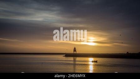 Blick auf den Fluss Tyne zur Nordsee, die Piers und die Groyne bei Sonnenaufgang Stockfoto