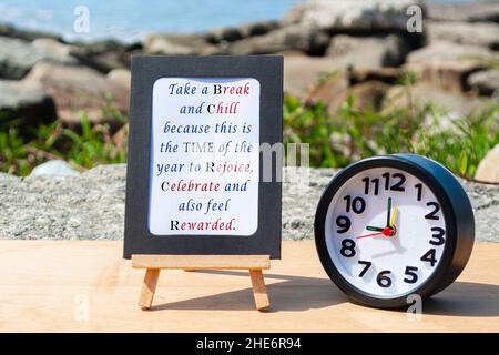 Motivierendes und inspirierendes Zitat auf einem Notizblock mit schwarzem Wecker Stockfoto