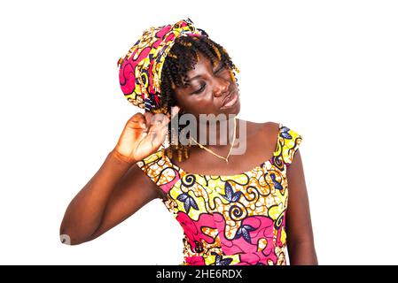 Schöne junge Frau in einem traditionellen Lendenschurz, der Finger ins Ohr legt. Stockfoto