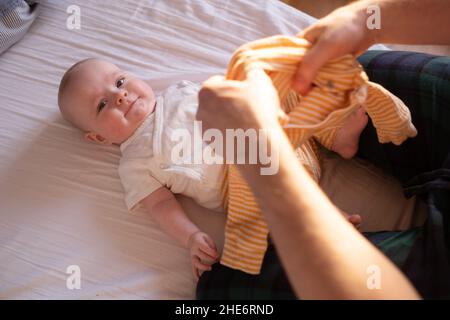 Kaukasische Eltern ändern und verkleiden Baby. Stockfoto