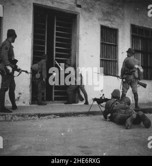 Zweiter Chinesisch-Japanischer Krieg, 1937-1945. Die Truppen der japanischen Marinelandungstruppen der 15th Verteidigungs-/Wacheinheit bereiten sich darauf vor, ein Gebäude zu stürmen, in dem sich chinesische Truppen im Nordosten der Insel Hainan um 1942 festigten. Die kaiserliche japanische Armee und die Marine starteten im Februar 1939 eine gemeinsame Gefangenenoperation der Insel Hainan, wobei letztere auf der Insel weiterhin aroniert blieb und an einer Reihe von Aufräumoperationen gegen den lokalen Widerstand bis zum Abschluss des Zweiten Chinesisch-Japanischen Krieges teilnahm. Stockfoto