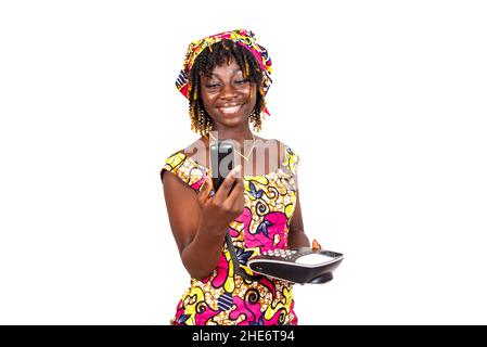 Schöne junge Frau in traditionellem Lendenschurz, die ihr Mobiltelefon anschaut und lächelt. Stockfoto