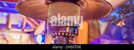 Design Edelstahl Metall Gas brennende Innenterrasse Heizung mit verschwommenem enteriour Hintergrund BANNER, LANG FORMAT Stockfoto