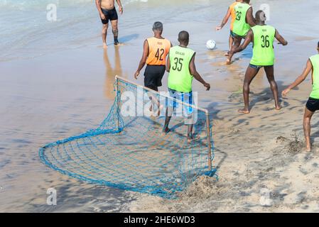 Salvador, Bahia, Brasilien - 15. August 2021: Menschen spielen Sandfußball am Strand Farol da Barra in Salvador, Bahia, Brasilien. Stockfoto