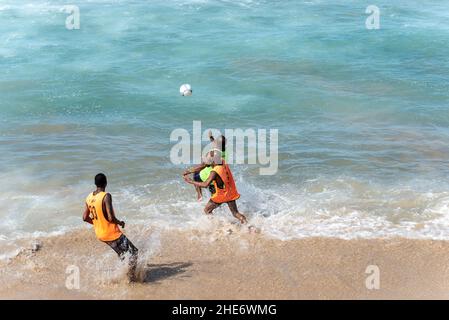 Salvador, Bahia, Brasilien - 15. August 2021: Menschen spielen Sandfußball am Strand von Farol da Barra in Salvador, Bahia, Brasilien. Stockfoto