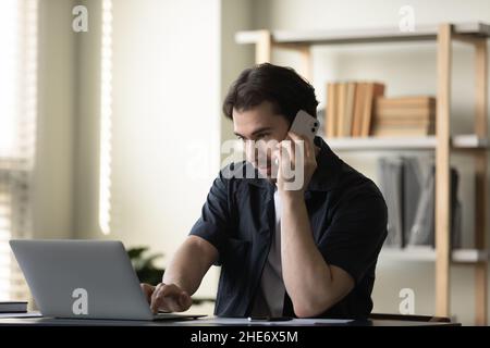 Fokussierter junger Geschäftsmann, der im modernen Büro multitasking. Stockfoto