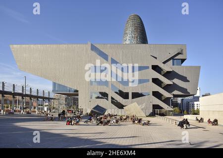 Menschen auf Stühlen, die sich vor dem Museu del Disseny (Design Museum) mit dem Wolkenkratzer Torre Glories im Hintergrund entspannen, Barcelona Spanien. Stockfoto