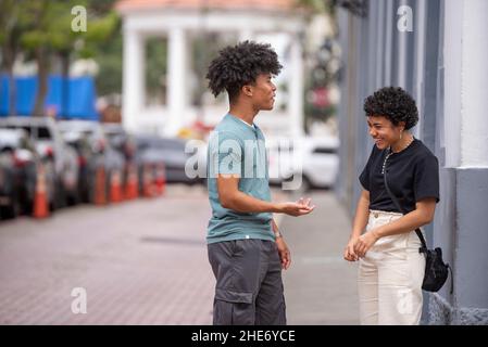 Hispanische Jugendliche plaudern auf dem Bürgersteig, Panama City Stockfoto