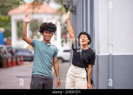 Lateinisches Paar, das Hände auf dem Bürgersteig winkt, Panama City Stockfoto