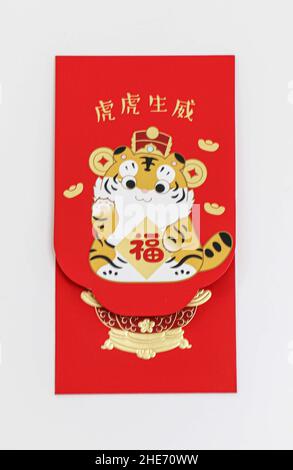 Ein einzelner chinesischer Neujahrsumschlag in Rot mit Tiger-Jahr-Design, auf weißem Hintergrund, chinesische Schriftzeichen übersetzt als Segen Menschen mit Stärke und Stockfoto