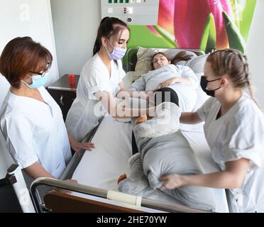 Bitterfeld, Deutschland. 04th. November 2021. An der Pflegeschule der Berufsschulen Anhalt-Bitterfeld zeigen die angehenden Krankenschwestern Charlotte (l) und Anna (r) ihrem Lehrer, wie man bettlägerige Patienten richtig ernährt. Das Ausbildungszentrum Bitterfeld, das mit 2300 Unternehmen aus acht Bundesländern kooperiert, hat in diesem Jahr mit 2700 Studierenden und Auszubildenden in 68 Ausbildungsberufen einen leichten Anstieg verzeichnet. Die Auszubildenden werden in 155 Klassen in fünf Schularten und einer Krankenpflegeschule unterrichtet. Quelle: Waltraud Grubitzsch/dpa-Zentralbild/dpa/Alamy Live News Stockfoto