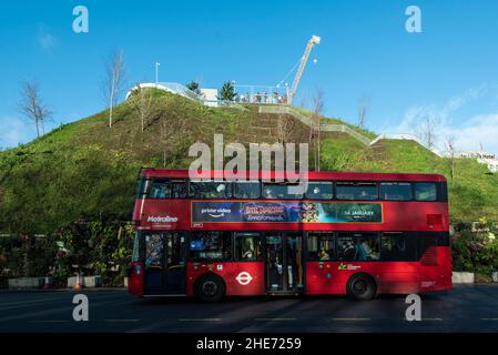 London, Großbritannien. 9. Januar 2022. Ein Bus fährt am Marble Arch Mound vorbei. Die Struktur schließt heute nach sechs Monaten, in denen Melvyn Caplan, der stellvertretende Vorsitzende des Westminster City Council, zurücktrat, nachdem die Kosten für den Hügel, der ursprünglich als £2m gemeldet wurde, auf £6m geschätzt wurden. Der vom rat in Auftrag gegebene und von MVRDV Architekten entworfene, 25m hohe künstliche Hügel wurde heftig als unvollständig kritisiert, ohne die angepriesene Aussicht, zu teuer für einen Besuch und als „das schlechteste Wahrzeichen Londons“. Kredit: Stephen Chung / Alamy Live Nachrichten Stockfoto