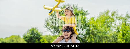 Gerne Vater und Sohn spielen mit Spielzeug Flugzeug gegen alte Landebahn Hintergrund. Mit Kindern unterwegs Konzept BANNER, LANGE FORMAT Stockfoto