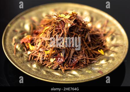 Eine Schüssel mit Rooibos-Teeblättern mit getrockneten Blütenblättern Stockfoto