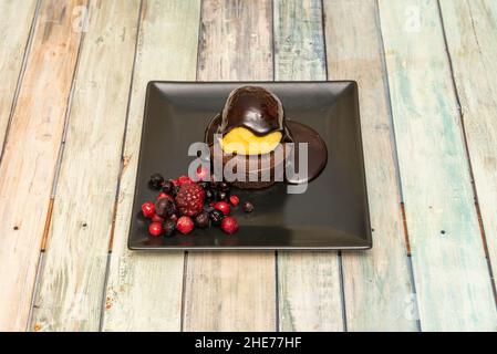 Cremige Schokoladenschokolade, die innen mit Sirup und Vanilleeis und Beeren schmilzt Stockfoto