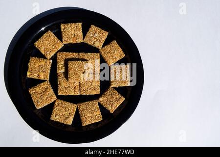 Cholai KI chikki oder Rajgira chikki aus Amaranth-Samen und Jagery. Makar sankranti Indian Festival Fasten Süßigkeiten Essen. Auf weißem Hintergrund Stockfoto