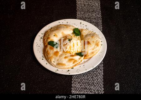 Samosa ist ein gebratener oder gebackener Knödel mit herzhafter Füllung, wie z. B. würzige Kartoffeln, Zwiebeln, Erbsen, Fleisch oder Linsen. Es kann verschiedene Formen annehmen, einschließlich Stockfoto