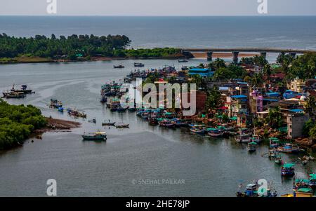 RATNAGIRI, INDIEN - 19. November 2021 : Panoramablick auf Fischerboote am Someshwar Creek in der Nähe der Fischerkolonie, der Bhatia-Brücke und des Arabischen Meeres Fr. Stockfoto