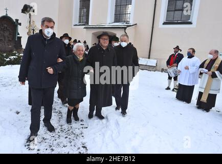 Oberammergau, Deutschland. 09th Januar 2022. Markus Söder, Bayerischer Ministerpräsident (CSU, l-r), Max Streibls Witwe Irmingard Streibl und sein Sohn Florian Streibl kommen zum Gedenken an den 90th. Geburtstag des ehemaligen bayerischen Ministerpräsidenten Max Streibl auf dem örtlichen Friedhof zusammen. Quelle: Karl-Josef Hildenbrand/dpa/Alamy Live News Stockfoto