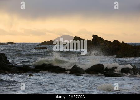 Dunure, Ayrshire, Schottland, Großbritannien an einem Wintertag an der Ayrshire Coast, Firth of Clyde, stürzen Wellen auf die felsige Küste Stockfoto