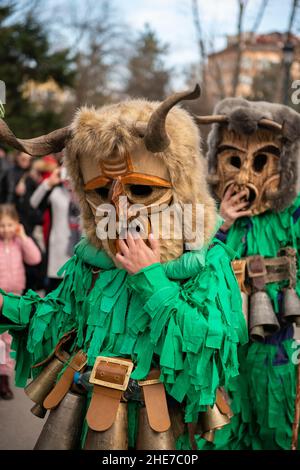 Kukeri-Tänzer mit komplizierten Kostümen, großen Glocken und Masken tanzen beim traditionellen jährlichen Festival in Sofia, Bulgarien. Kukeri ist eine jahrhundertealte Tradition, die böse Geister vertreiben und gute einladen soll, die um den frühen Winter oder die Wintermitte abgehalten wird. Stockfoto