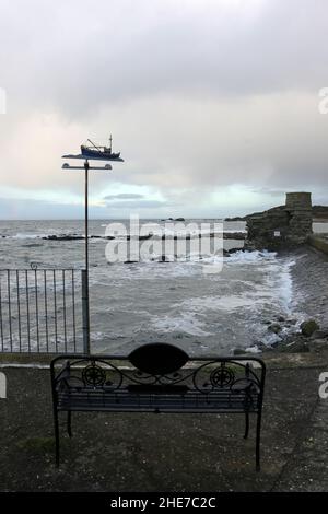Dunure, South Ayrshire, Schottland, Großbritannien. Meereswellen stürzen auf die Hafenmauer, die den Eingang schützt. Fischerboot Weathervain Stockfoto