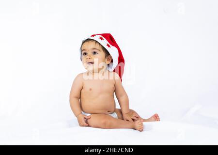 Ein kleiner Junge mit einem roten weihnachtshut auf weißem Hintergrund, Platz kopieren Stockfoto