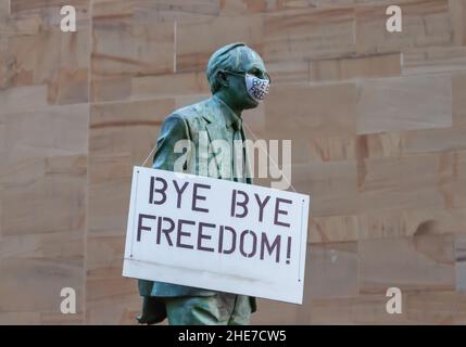 Glasgow, Schottland, Großbritannien. 9th. Januar 2022. Die Statue des ersten schottischen Ministers Donald Dewar oben in der Buchanan Street bekommt eine Gesichtsmaske und ein Schild mit den Aufschrift Bye Bye Freedom. Kredit: Skully/Alamy Live Nachrichten Stockfoto