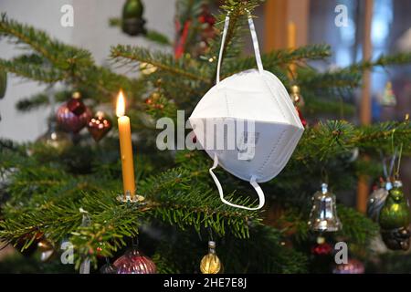 FFP2-Maske hängt auf einem Weihnachtsbaum, Österreich, Europa - FFP2 Maske hängt an einem Weihnachtsbaum, Österreich, Europa Stockfoto