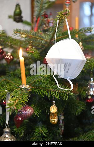 FFP2-Maske hängt auf einem Weihnachtsbaum, Österreich, Europa - FFP2 Maske hängt an einem Weihnachtsbaum, Österreich, Europa Stockfoto