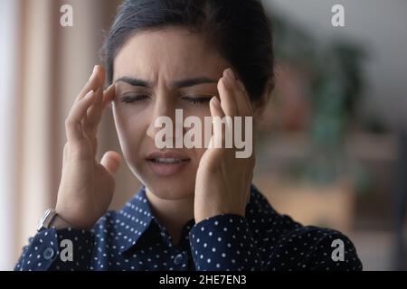 Unglücklich verärgert junge indische Frau, die unter Kopfschmerzen leidet Stockfoto