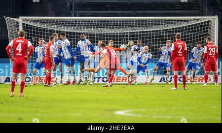 Berlin, Deutschland. 09th Januar 2022. Fußball: Bundesliga, Hertha BSC - 1. FC Köln, Matchday 18, Olympiastadion. Mark Uth (M) vom FC Köln legt einen Freistoß ein. Berliner Torwart Alexander Schwolow (M, gedeckt) macht sich einen Spare. Quelle: Andreas Gora/dpa - WICHTIGER HINWEIS: Gemäß den Anforderungen der DFL Deutsche Fußball Liga und des DFB Deutscher Fußball-Bund ist es untersagt, im Stadion und/oder vom Spiel aufgenommene Fotos in Form von Sequenzbildern und/oder videoähnlichen Fotoserien zu verwenden oder zu verwenden./dpa/Alamy Live News Stockfoto