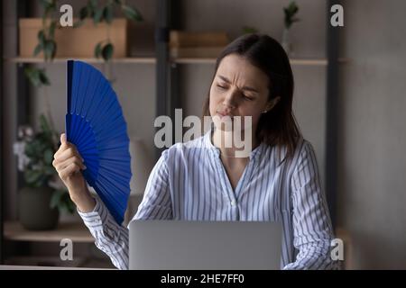 Erschöpfter Büroangestellter, der unter Hitze und stickiger Luft leidet Stockfoto