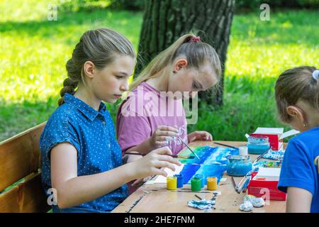 Zaporizhia, Ukraine- 19. Juni 2021: Charity Familienfest: Mädchen, die an Kunst und Handwerk im Freien Workshop teilnehmen, machen bunte Zeichnung mit Goua Stockfoto