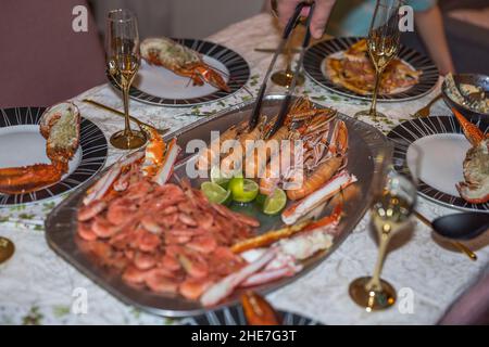 Nahaufnahme eines Mannes, der Fischgerichte auf den Tischen auslegt. Schweden. Stockfoto