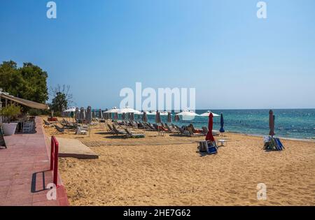 Toller weißer Sandstrand von Griechenland mit leeren Sonnenliegen und Sonnenschirmen. Griechenland. Stockfoto