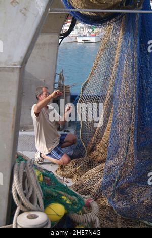 Cala Ratjada, Fischer beim Netze flicken, Mallorca, Balearen, Spanien, Europa | Cala Ratjada, Fischer repariert Netze, Mallorca, Balearen, Sp Stockfoto